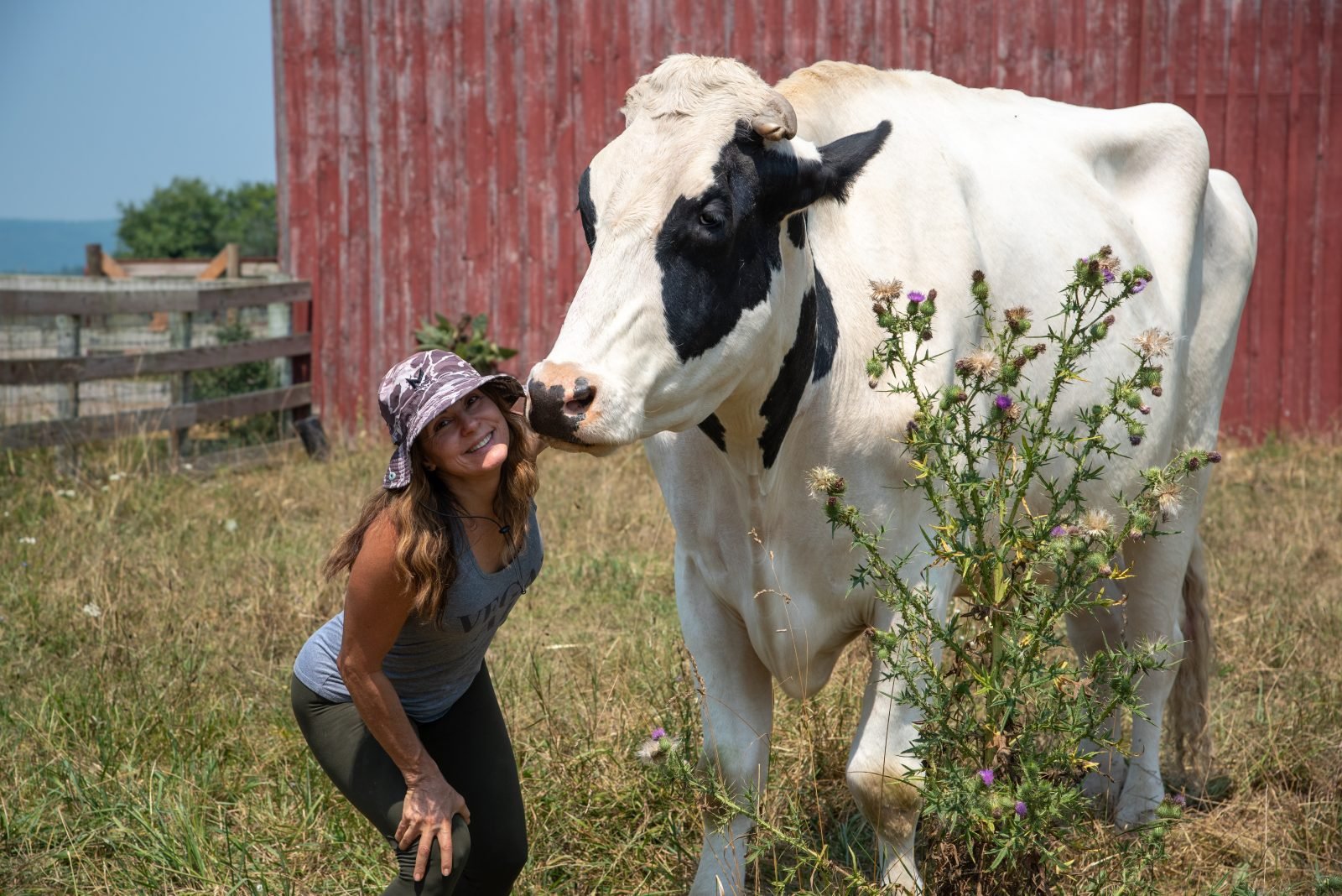 Guest smiles with rescued cow at Hoedown 2025 at Farm Sanctuary