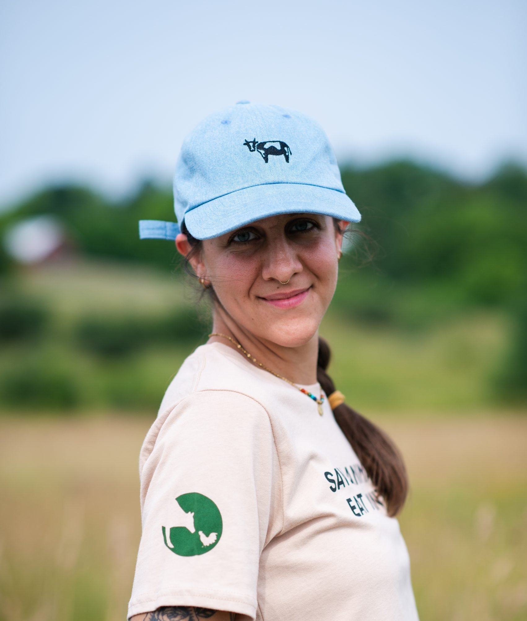 Farm Sanctuary staff Emily Grizzell wears blue embroidered cow hat