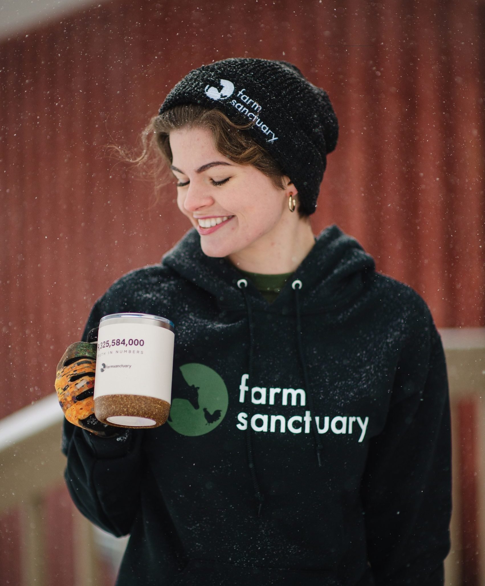 Staff Alice Scarpati with winter Farm Sanctuary merch