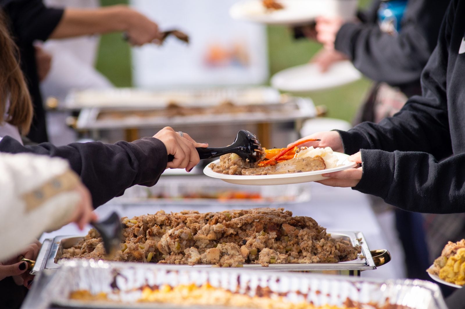 Vegan food is spooned onto a plate for a guest at Farm Sanctuary's Celebration for the Turkeys