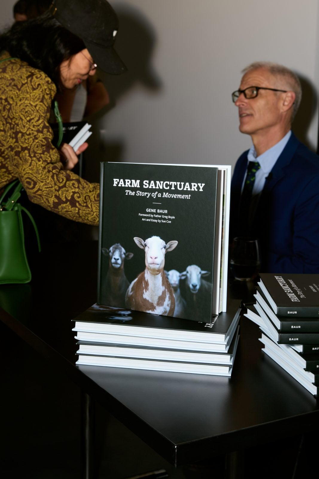 Gene Baur speaks with guest at book signing